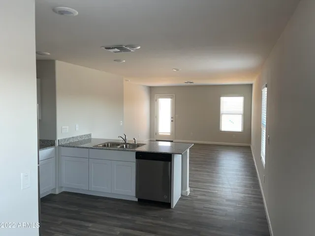 a kitchen with granite countertop a sink and cabinets