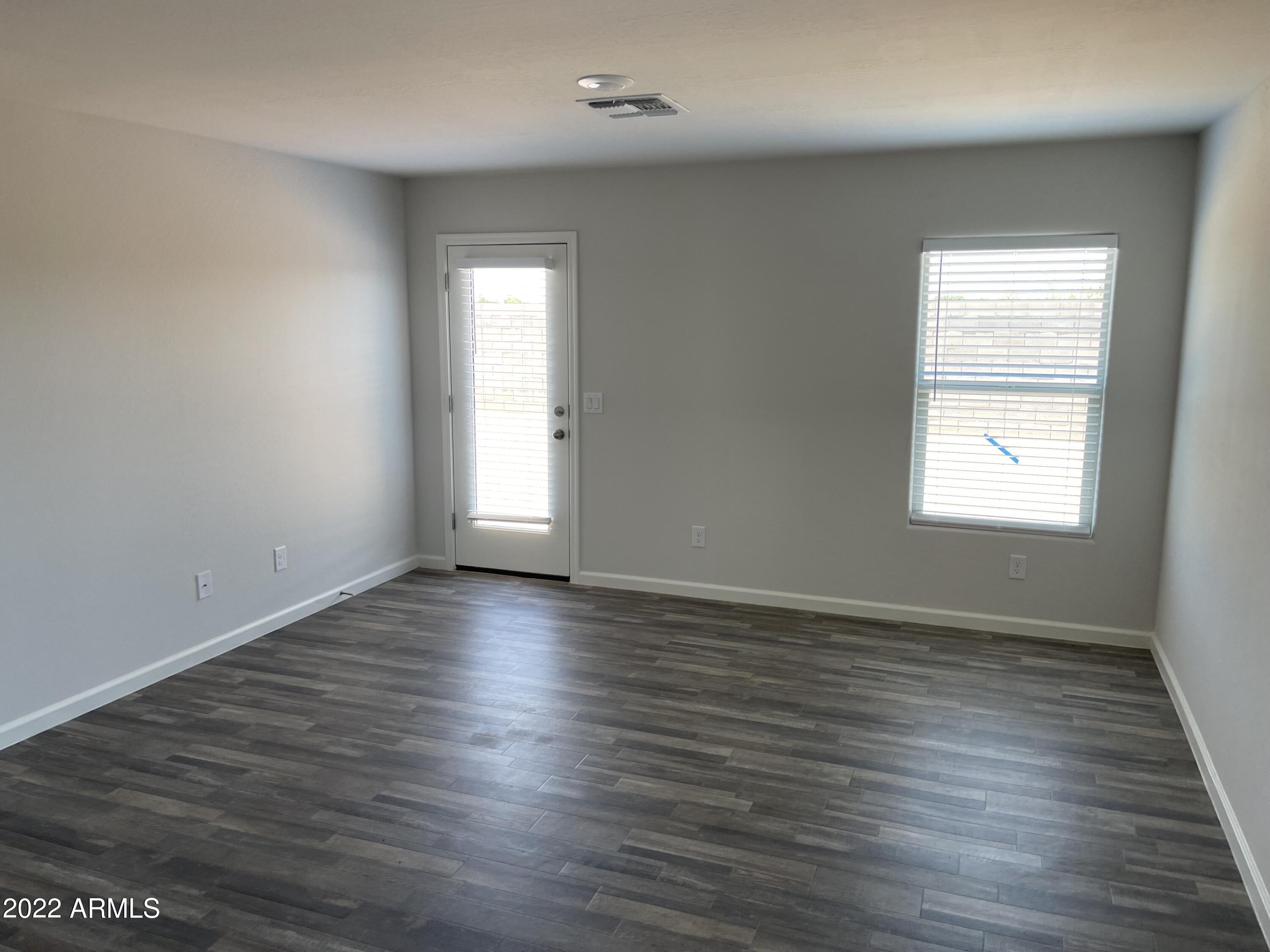 1099 9th Place Coolidge, AZ 85128 - Photo 6 of 11 an empty room with wooden floor and windows