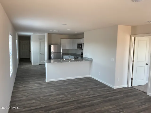 a view of a kitchen with wooden floor and a space