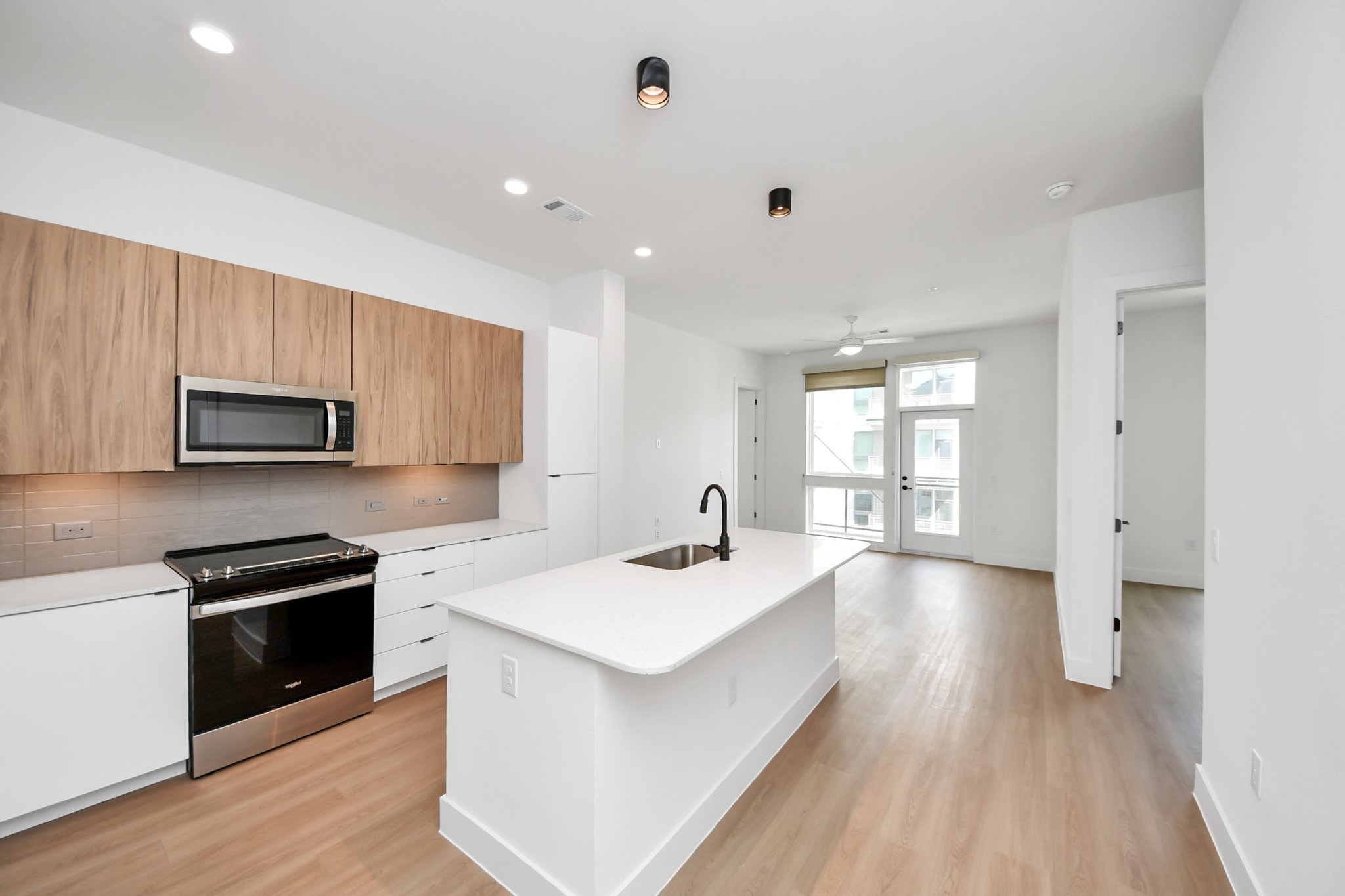 2810 Riverby Road, Unit 225 Houston, TX 77020 - Photo 3 of 47 a kitchen with stainless steel appliances kitchen island granite countertop a sink and a stove top oven with wooden floor