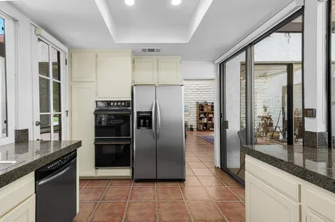 a kitchen with stainless steel appliances granite countertop a refrigerator and a sink