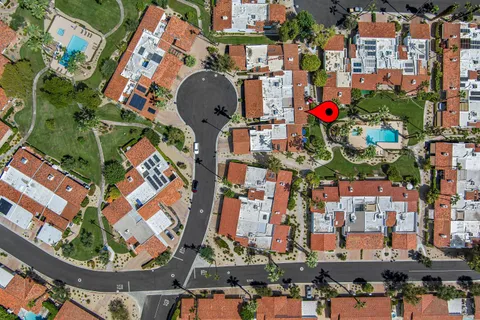a view of a swimming pool with a yard and palm trees