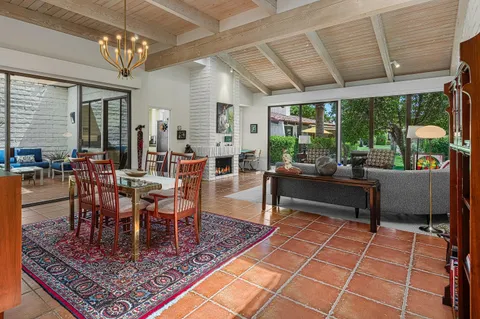 a living room with furniture a fireplace and a potted plant