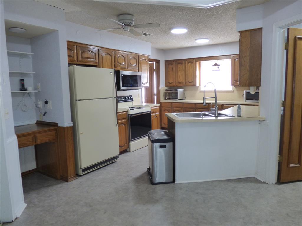 1506 East Peters Colony Road Carrollton, TX 75007 - Photo 13 of 33 a kitchen with refrigerator and cabinets