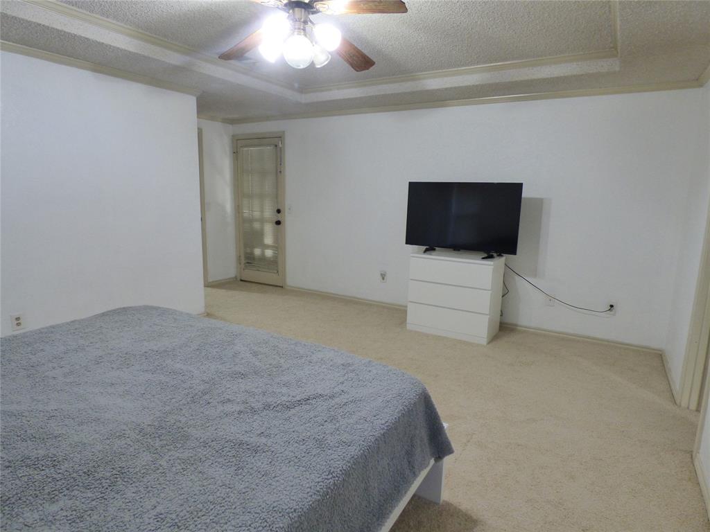 1506 East Peters Colony Road Carrollton, TX 75007 - Photo 16 of 33 a bedroom with a bed and a flat screen tv