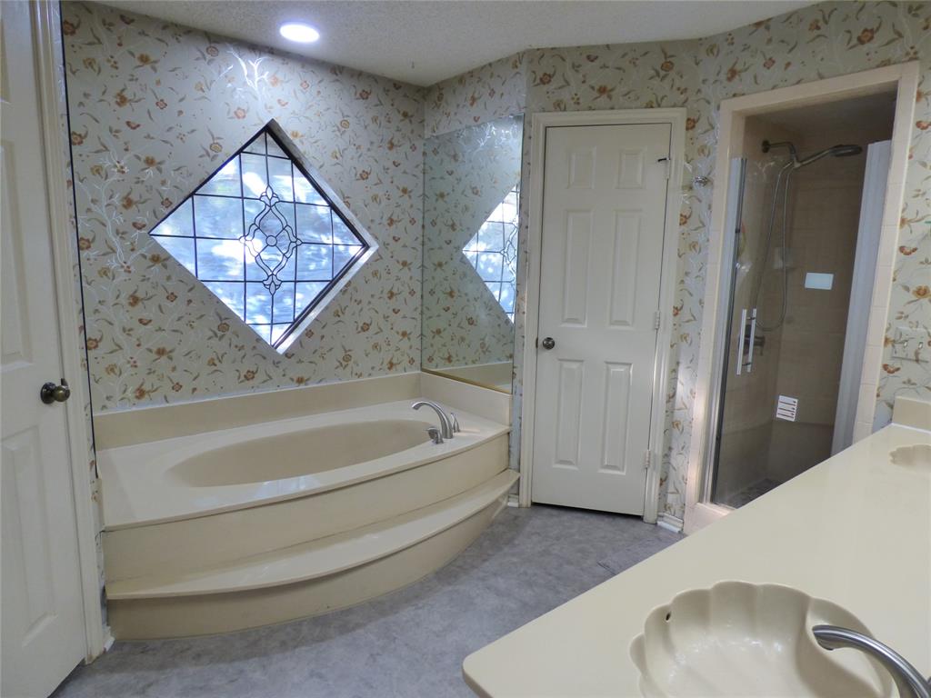 1506 East Peters Colony Road Carrollton, TX 75007 - Photo 18 of 33 a spacious bathroom with a bathtub and a shower