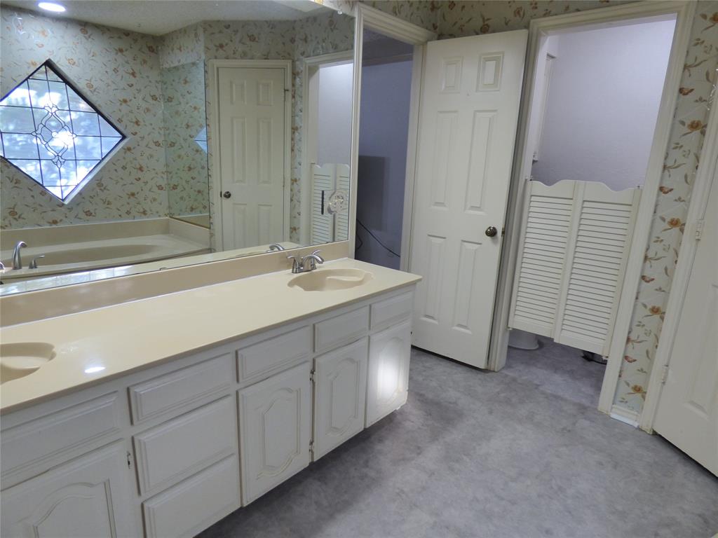 1506 East Peters Colony Road Carrollton, TX 75007 - Photo 19 of 33 a spacious bathroom with a sink a mirror and a shower