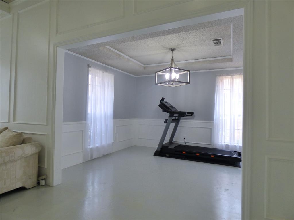 1506 East Peters Colony Road Carrollton, TX 75007 - Photo 8 of 33 a room with gym equipment and a mirror
