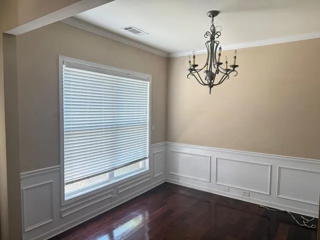 a view of empty room with window and wooden floor