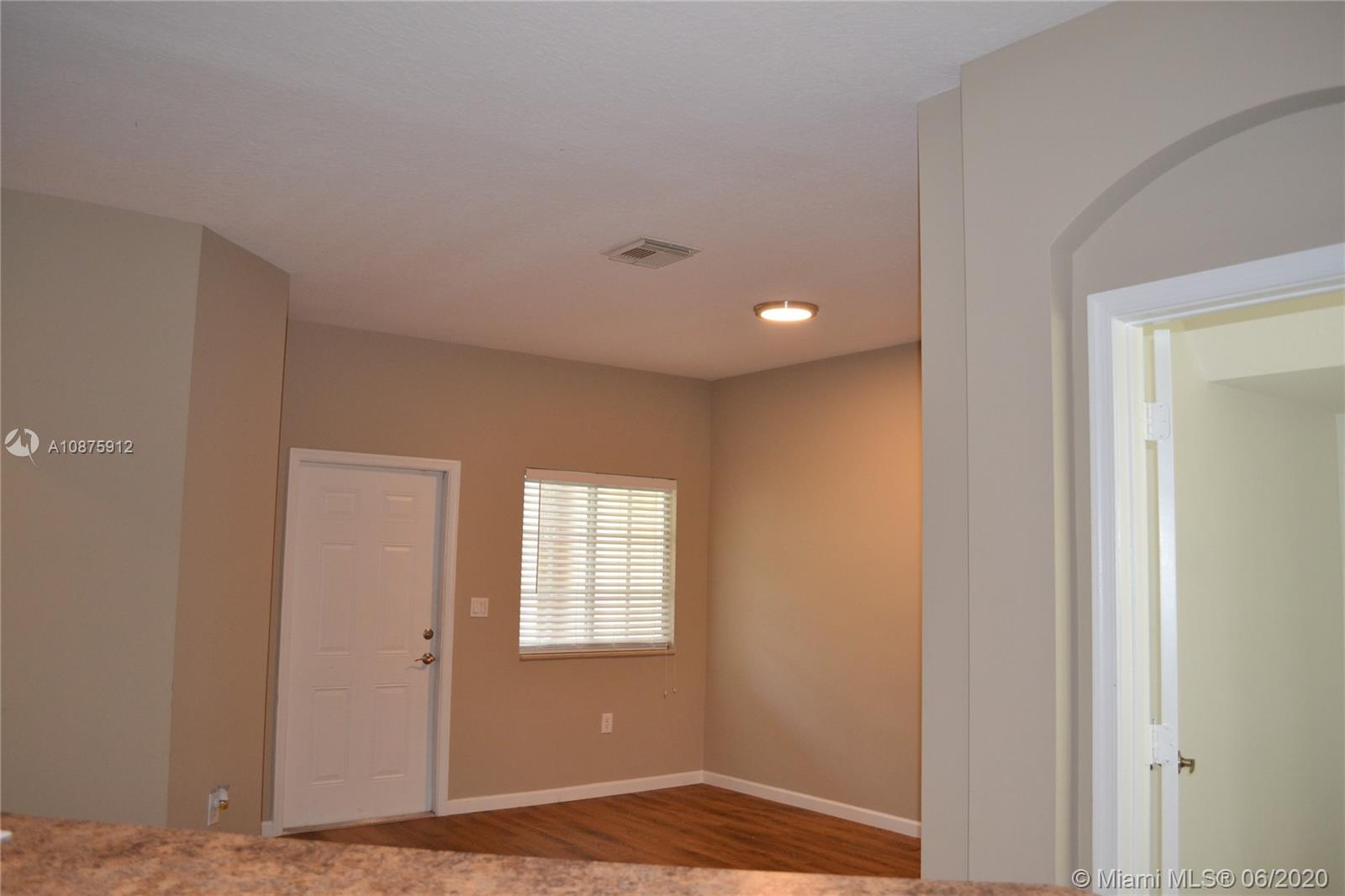 27951 Southwest 140th Avenue Homestead, FL 33032 - Photo 23 of 27 a view of an empty room with wooden floor and a window