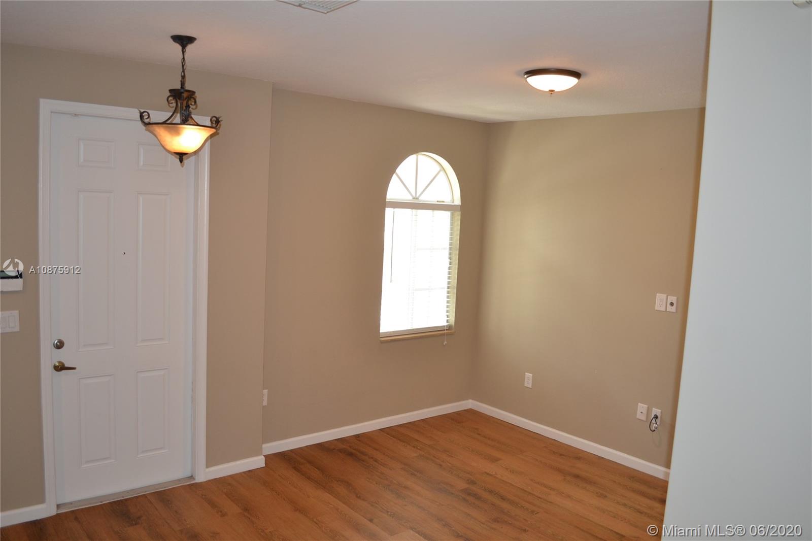 27951 Southwest 140th Avenue Homestead, FL 33032 - Photo 3 of 27 wooden floor in an empty room with a window