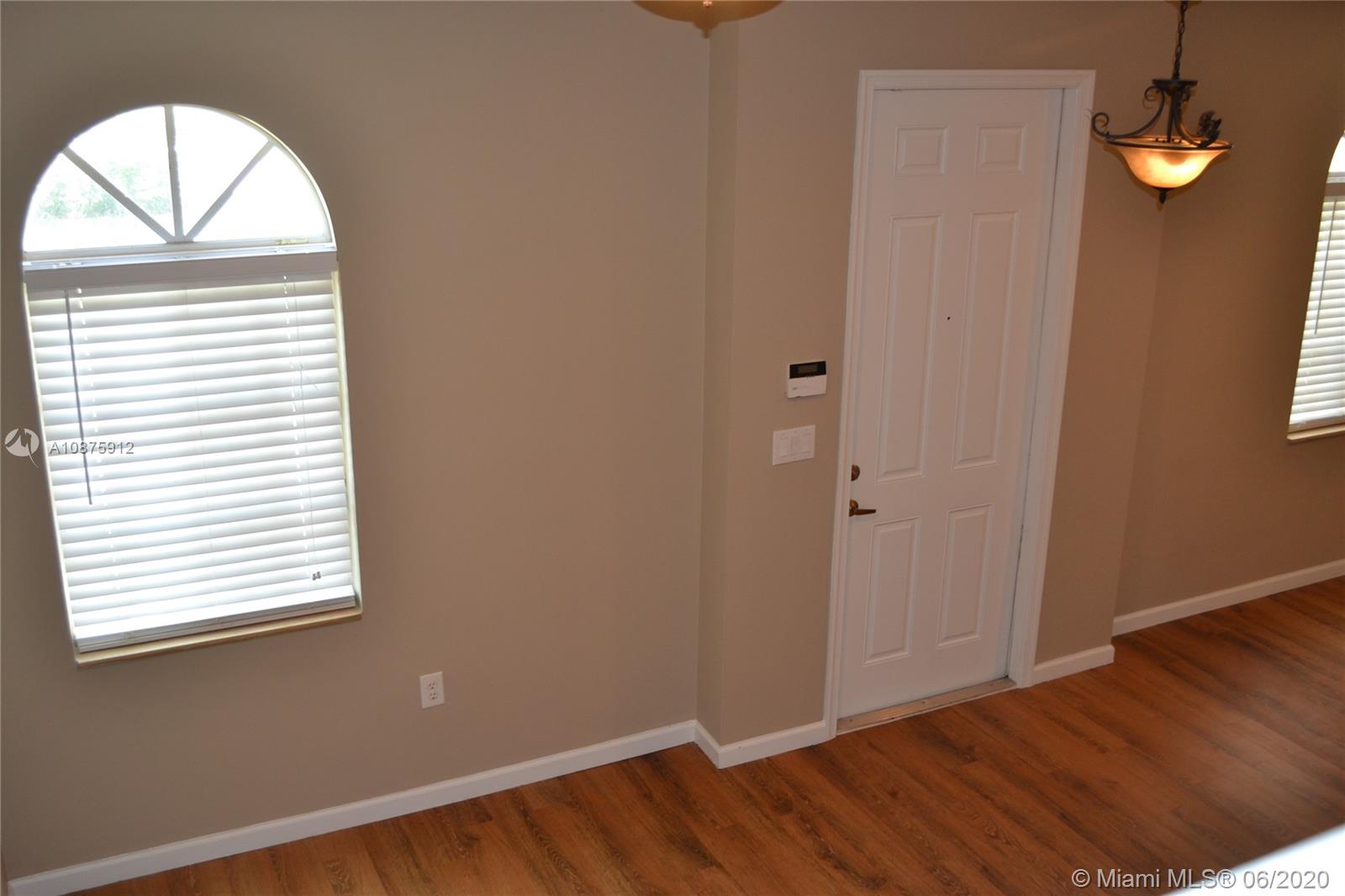 27951 Southwest 140th Avenue Homestead, FL 33032 - Photo 6 of 27 an empty room with wooden floor and windows