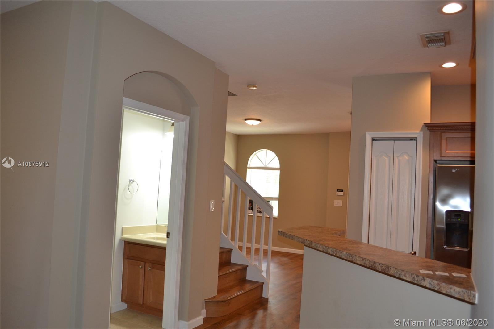 27951 Southwest 140th Avenue Homestead, FL 33032 - Photo 7 of 27 a view of a hallway with wooden floor and staircase