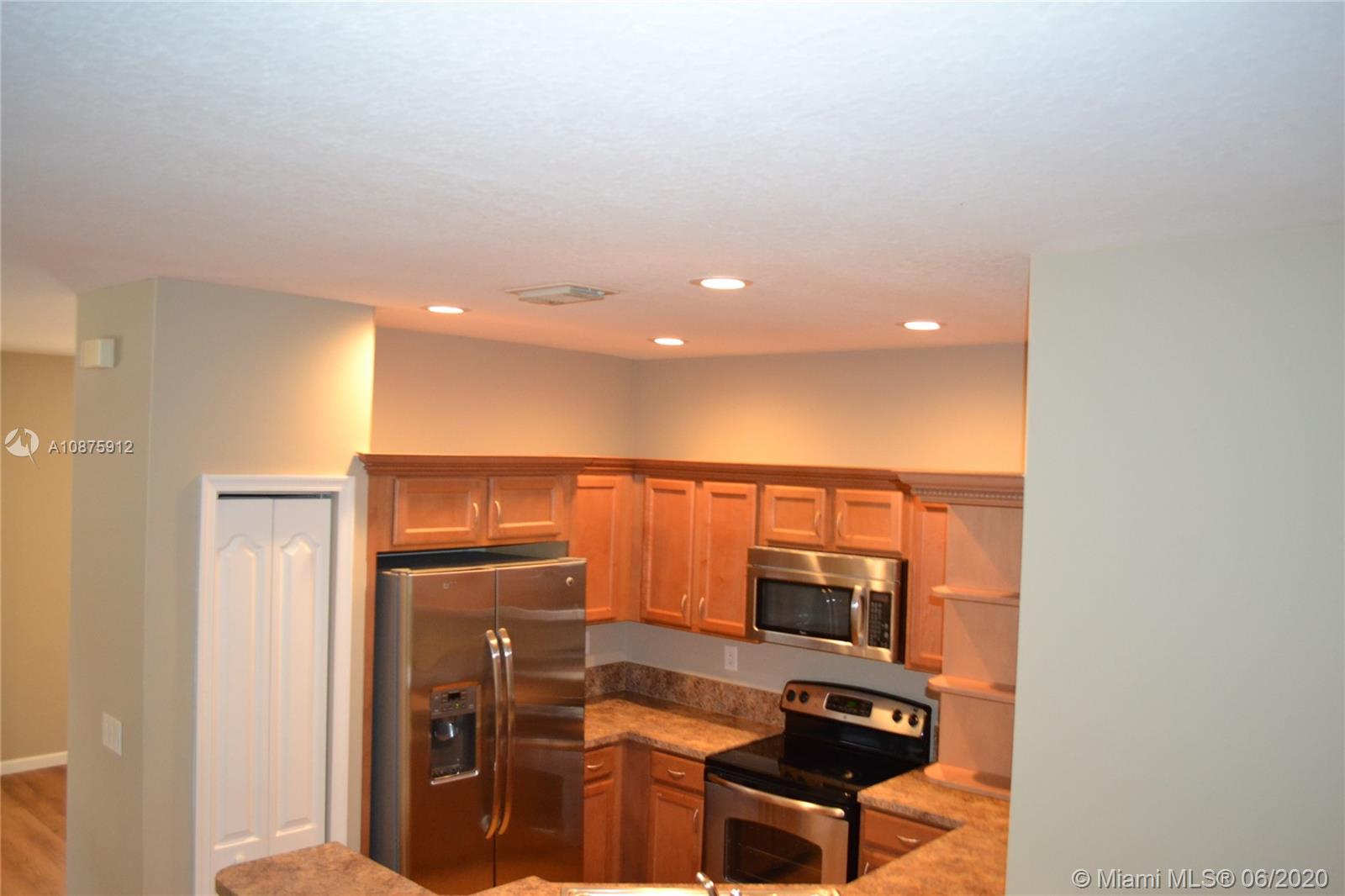 27951 Southwest 140th Avenue Homestead, FL 33032 - Photo 10 of 27 a kitchen with stainless steel appliances a refrigerator and a stove top oven