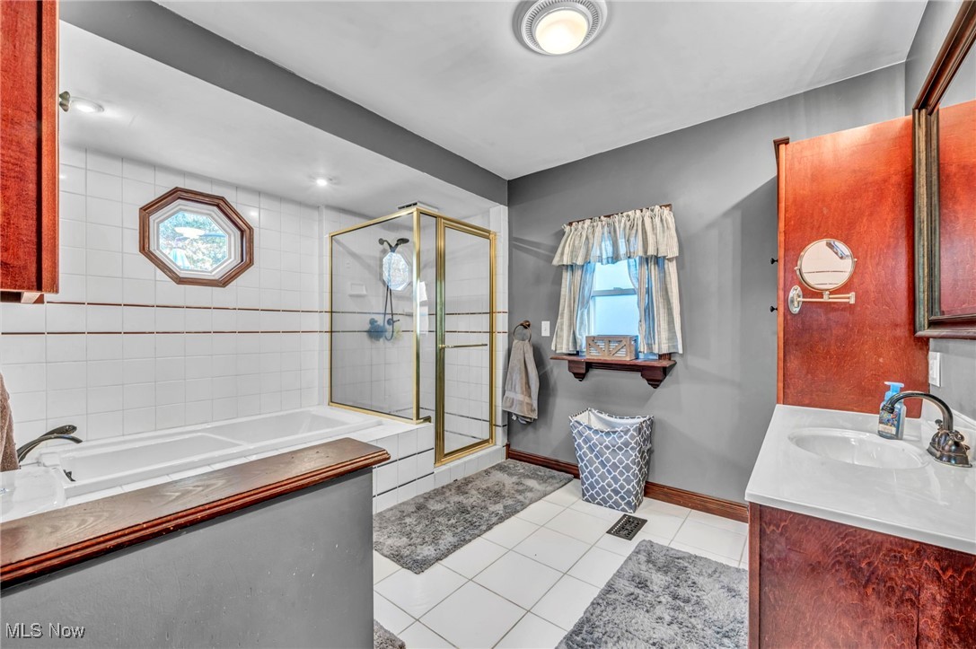 149 Jaycox Road Avon Lake, OH 44012 - Photo 32 of 42 Full bath featuring a bath, light tile patterned floors, a stall shower, and vanity