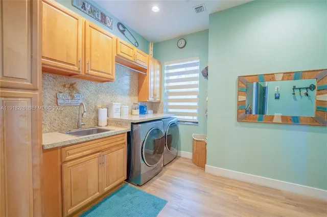a kitchen with stainless steel appliances granite countertop a sink and cabinets with wooden floor