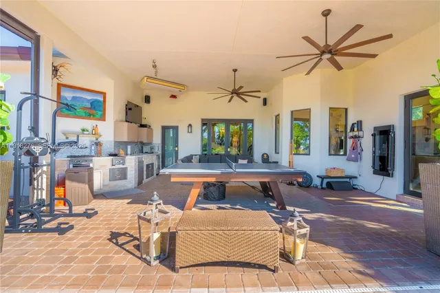 a living room with patio furniture and a large window