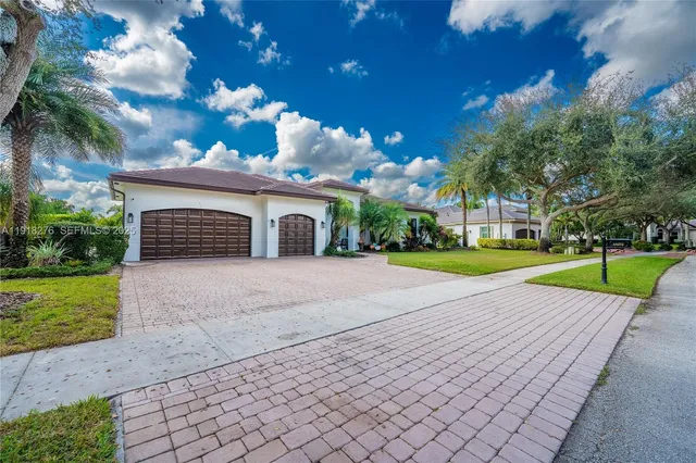 a view of a house with a yard and large tree