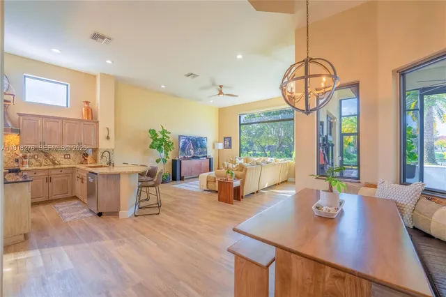 a view of a dining room and livingroom with furniture wooden floor a chandelier