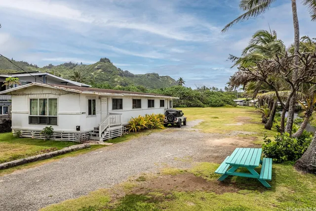 a view of a house with backyard and sitting area