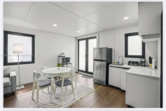 a kitchen with refrigerator and chairs