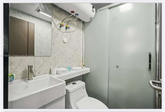 a bathroom with a sink toilet and shower