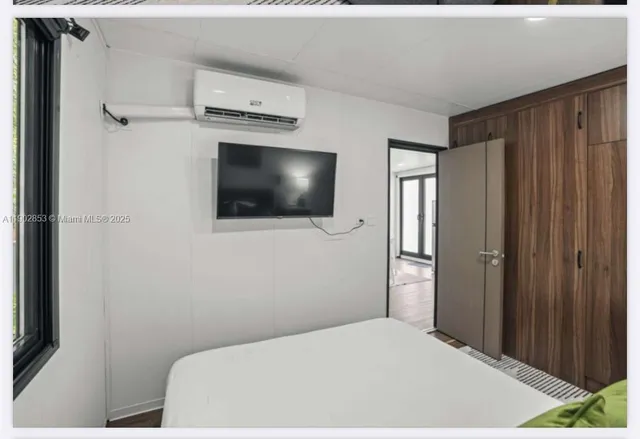 a bedroom with a bed and a flat screen tv