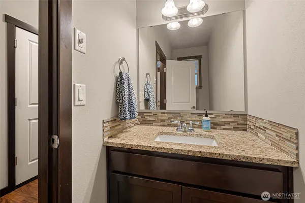 a bathroom with a granite countertop sink and a mirror
