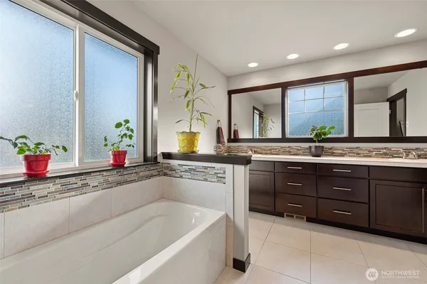 a spacious bathroom with a granite countertop sink and a bathtub