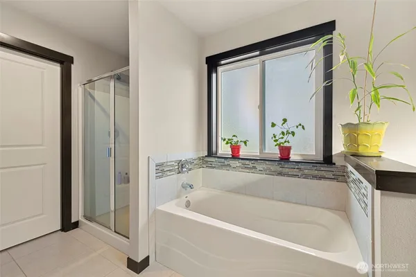 a white bath tub sitting next to a blue sink and a mirror