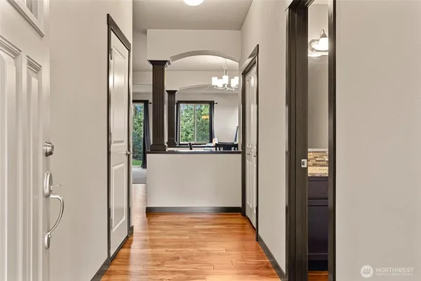 a view of a hallway with wooden floor and a living room