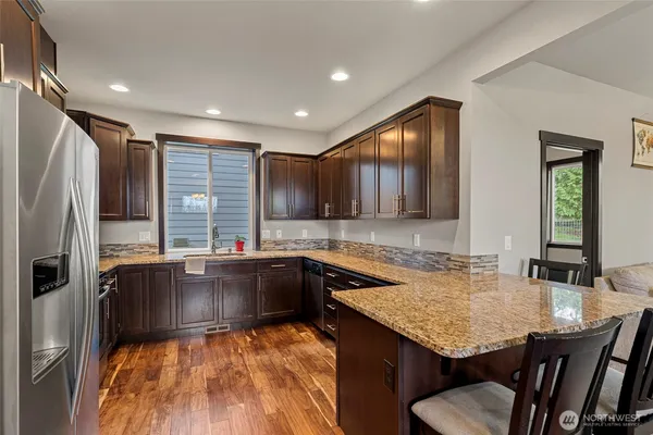 a large kitchen with granite countertop a sink and a refrigerator