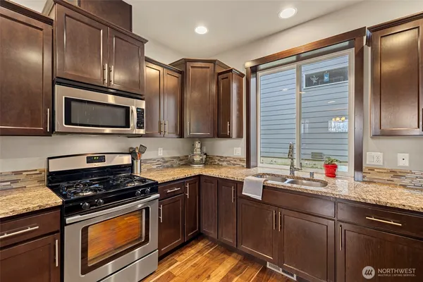 a kitchen with stainless steel appliances a sink stove microwave and cabinets