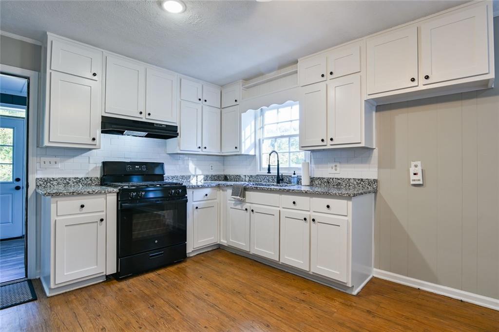 8196 Lakeview Drive Southwest Covington, GA 30014 - Photo 13 of 51 a kitchen with granite countertop white cabinets and black appliances