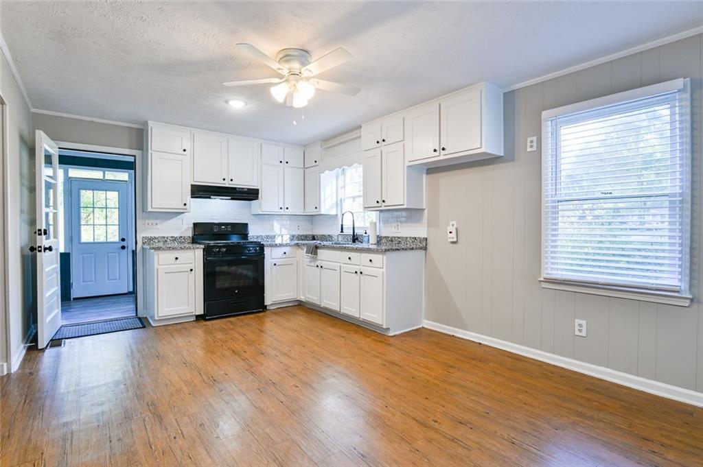 8196 Lakeview Drive Southwest Covington, GA 30014 - Photo 14 of 51 a kitchen with granite countertop a stove top oven cabinets and a window