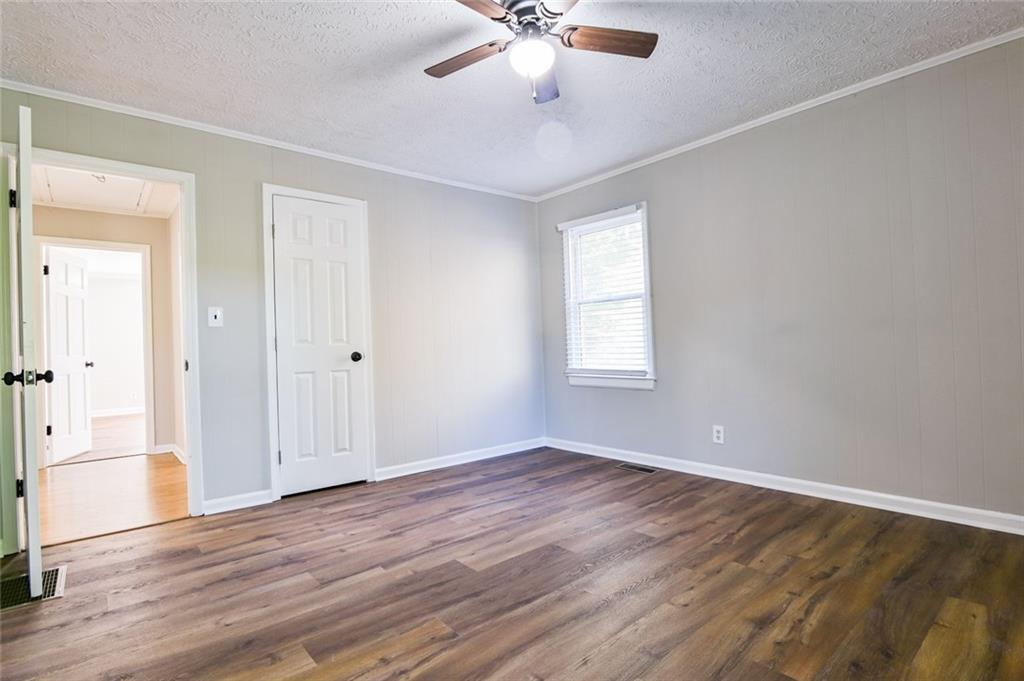 8196 Lakeview Drive Southwest Covington, GA 30014 - Photo 16 of 51 an empty room with wooden floor chandelier fan and windows