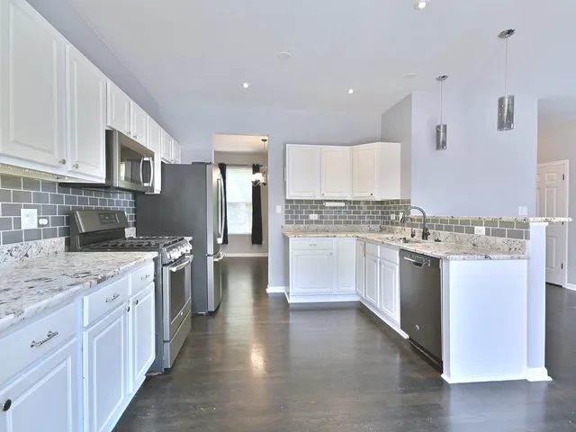 a kitchen with a refrigerator and a stove top oven