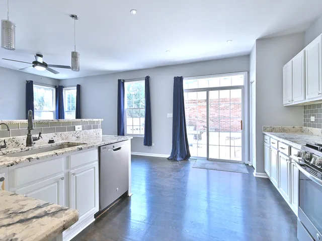 a large kitchen with a lot of counter space and wooden floor