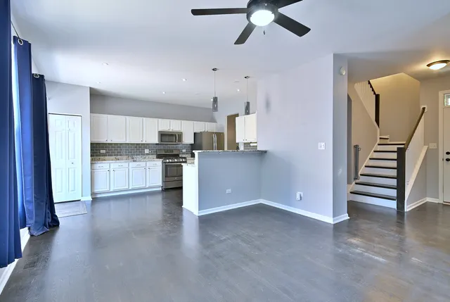 a view of a kitchen with wooden floor and electronic appliances