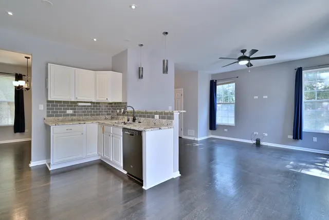 a kitchen with granite countertop white cabinets and white appliances