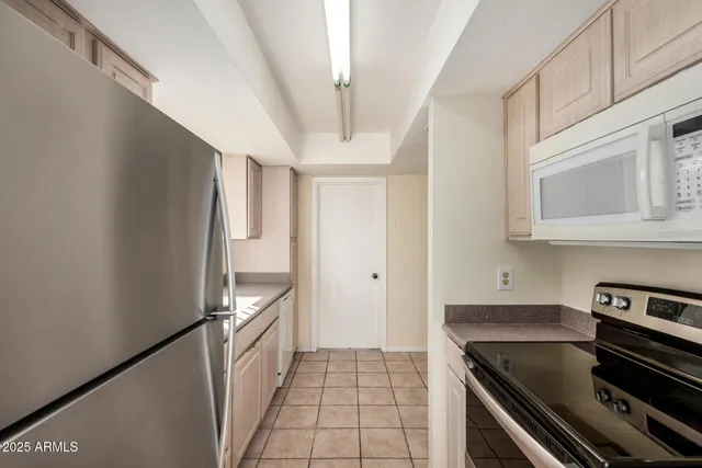 a view of a kitchen with a sink and wooden cabinets