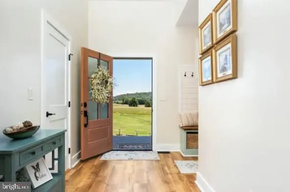 a kitchen with stainless steel appliances kitchen island granite countertop a table chairs and a wooden floor