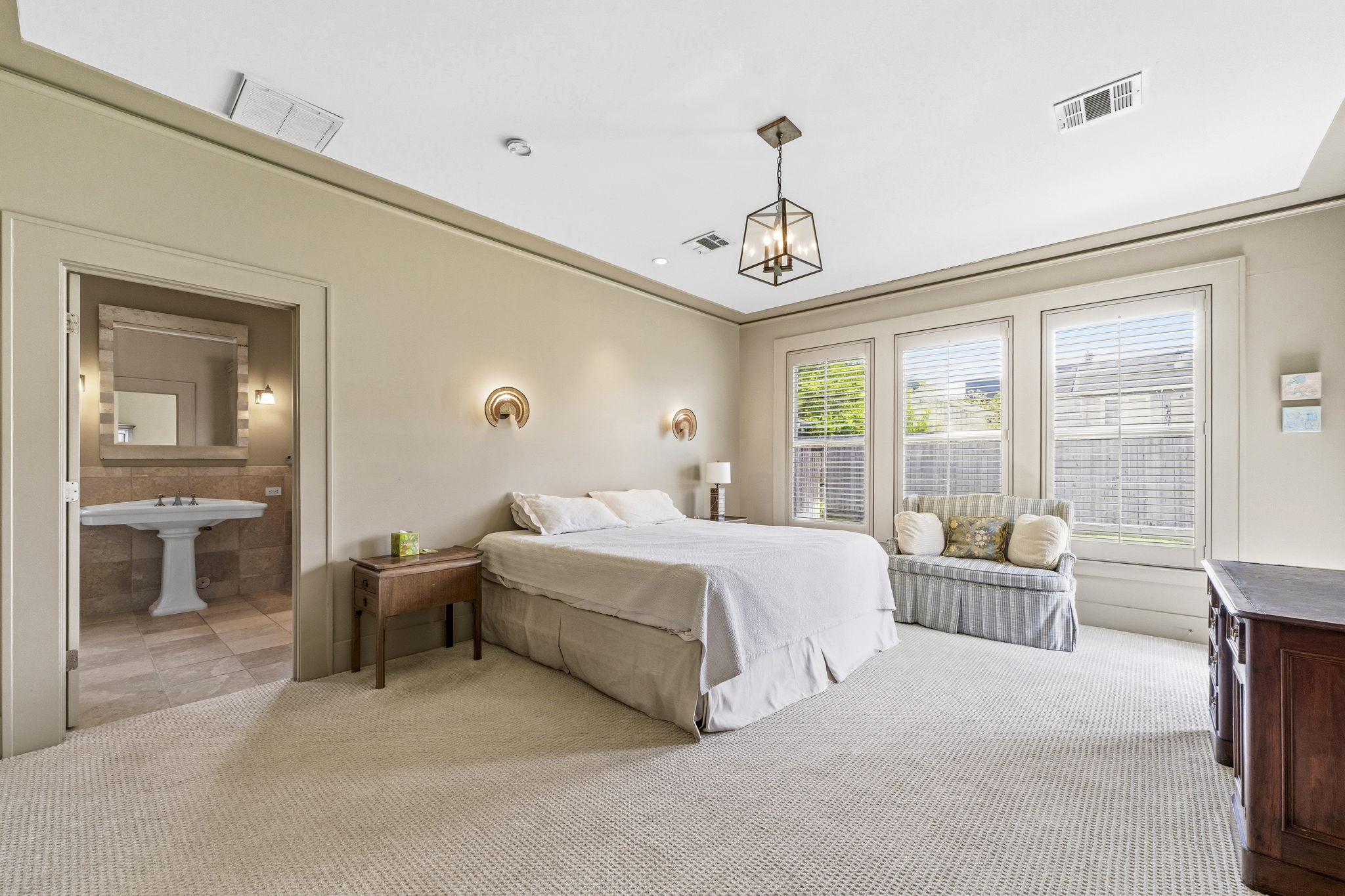 1521 Kipling Street Houston, TX 77006 - Photo 21 of 35 This spacious bedroom features large windows for ample natural light, a cozy seating area, and an en-suite bathroom with classic tiling.