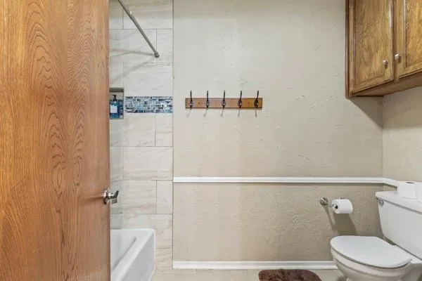 a white toilet sitting next to a shower