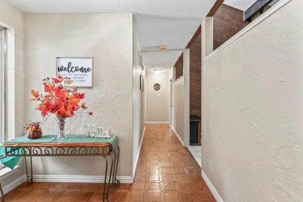 a view of a hallway with wooden floor and furniture