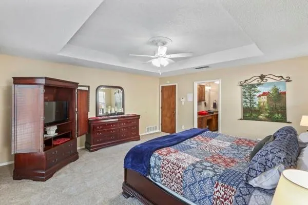 a bedroom with a bed and dresser with mirror