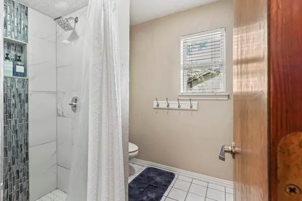 a bathroom with a granite countertop sink a toilet and shower