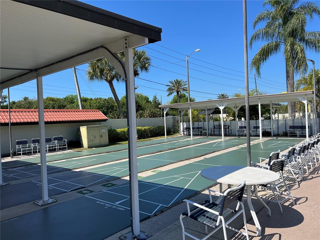 1100 East Bay Drive, Unit 35 Largo, FL 33770 - Photo 16 of 34 a view of a patio with table and chairs under an umbrella