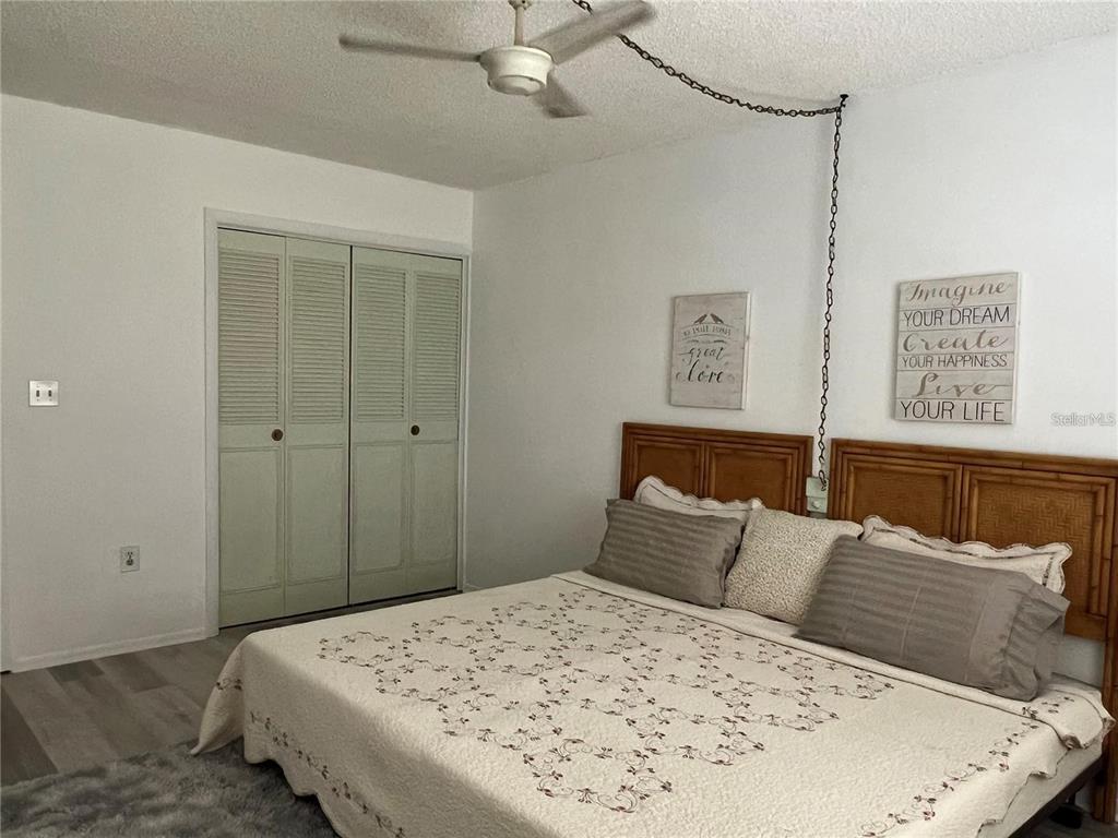 1100 East Bay Drive, Unit 35 Largo, FL 33770 - Photo 7 of 34 a bedroom with a bed and a painting on the wall
