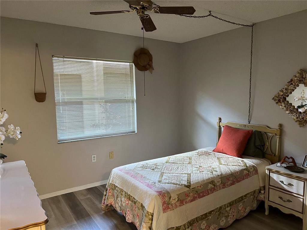 1100 East Bay Drive, Unit 35 Largo, FL 33770 - Photo 10 of 34 a bedroom with a bed and wooden floor